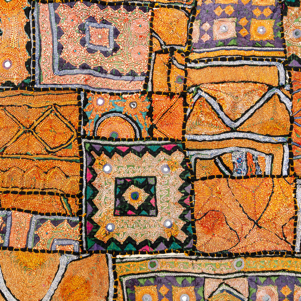 Vintage embroidered textile wall hanging with intricate handwork and visible signs of age.
