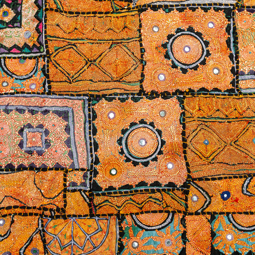Vintage embroidered textile wall hanging with intricate handwork and visible signs of age.
