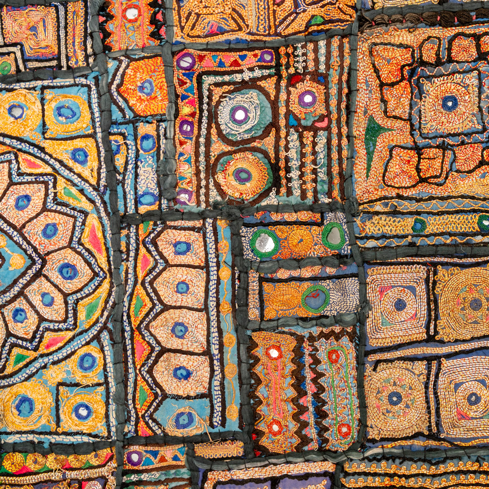 Vintage embroidered textile wall hanging with intricate handwork and visible signs of age.