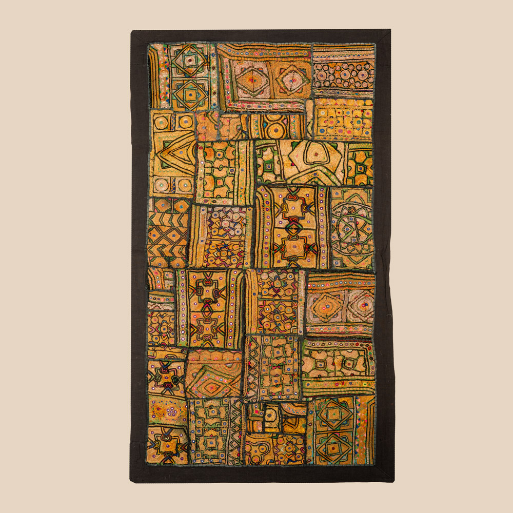 Vintage embroidered textile wall hanging with intricate handwork and visible signs of age.