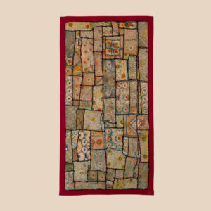 Vintage embroidered textile wall hanging with intricate handwork and visible signs of age.