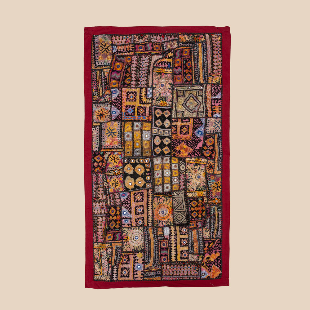 Vintage embroidered textile wall hanging with intricate handwork and visible signs of age.
