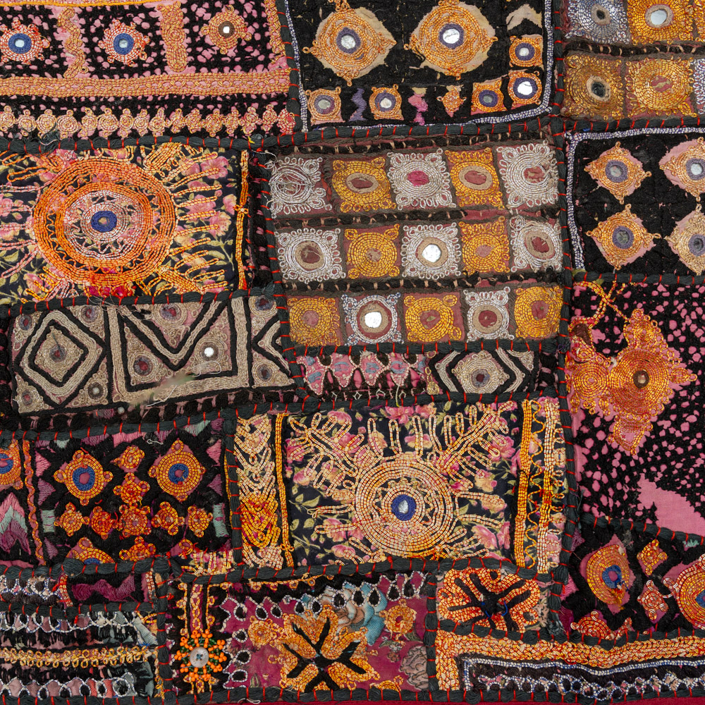 Vintage embroidered textile wall hanging with intricate handwork and visible signs of age.