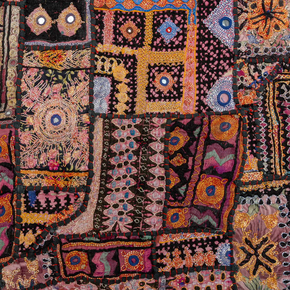 Vintage embroidered textile wall hanging with intricate handwork and visible signs of age.