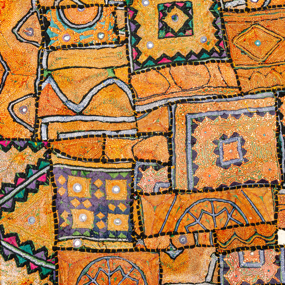 Vintage embroidered textile wall hanging with intricate handwork and visible signs of age.