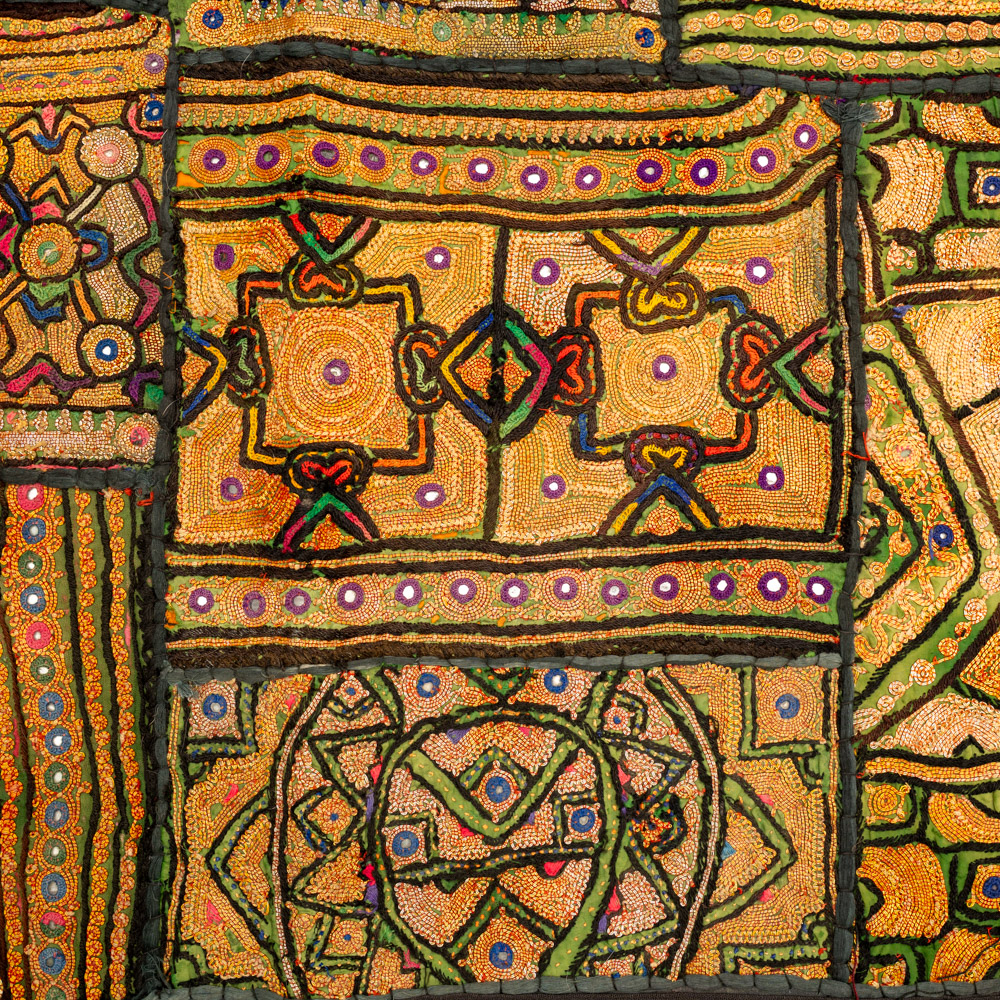 Vintage embroidered textile wall hanging with intricate handwork and visible signs of age.