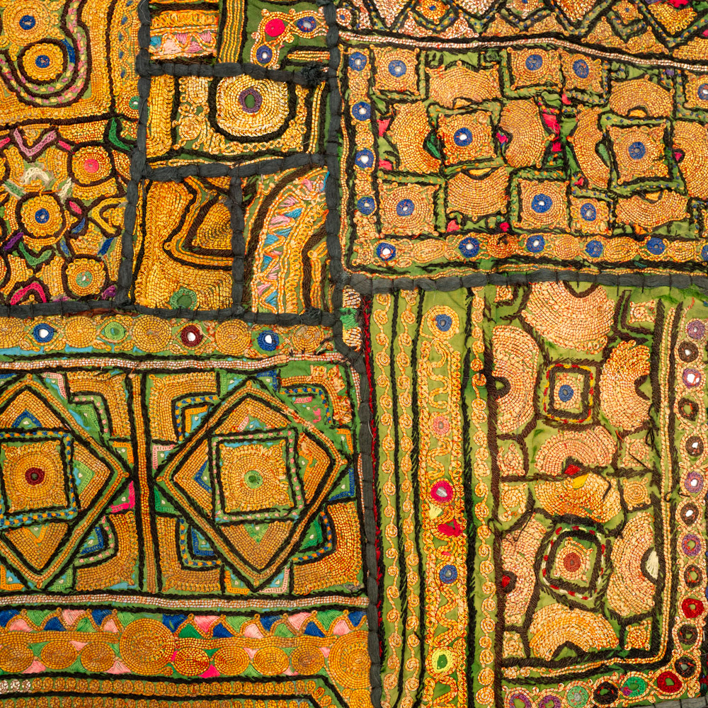 Vintage embroidered textile wall hanging with intricate handwork and visible signs of age.